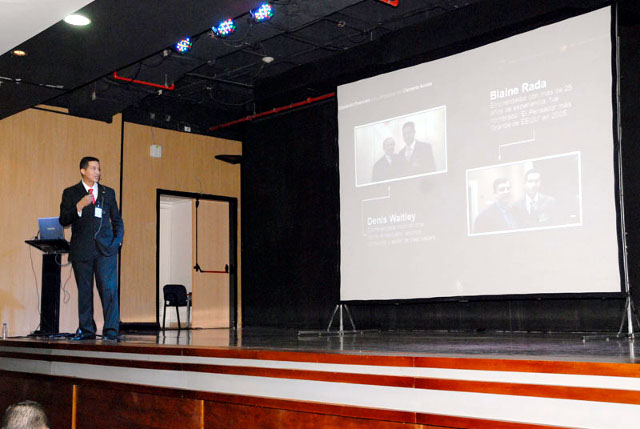Clemente Acosta con micrófono sobre el escenario durante una conferencia