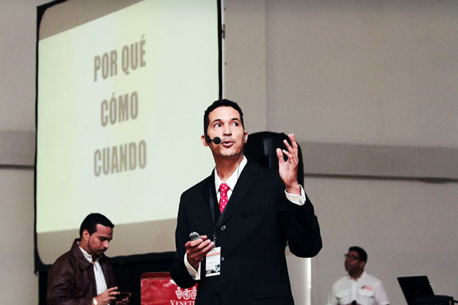 Clemente Acosta dando una presentación, con las palabras por qué, cómo y cuándo proyectadas detrás